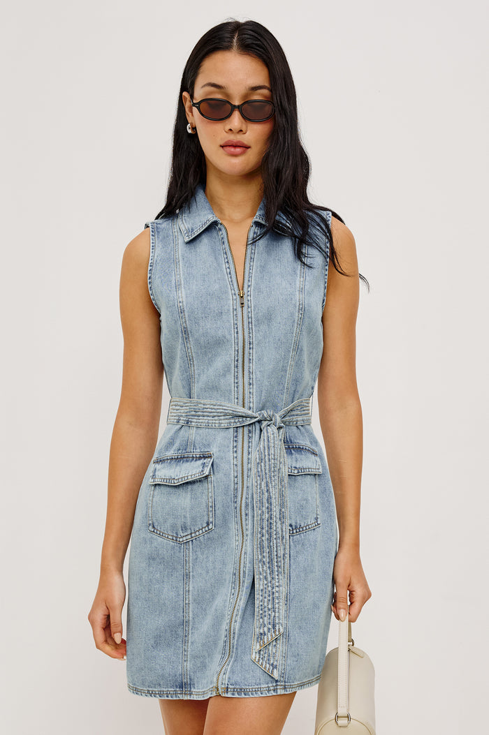 Aurora Sleeveless Mini Dress in TENCEL™Denim With Collar Front Exposed Zipper Adjustable Belted Ties Side Flap Pockets in Faded Indigo Colorway - Upper Body Front View Featured on Model