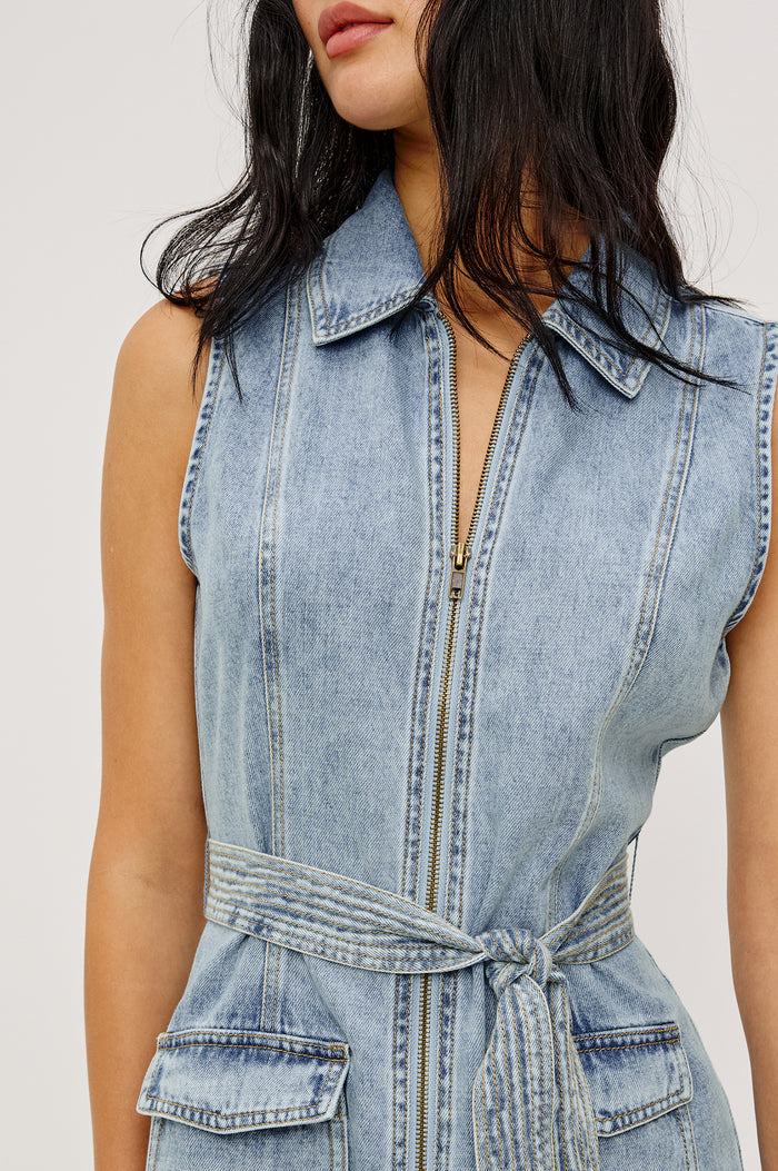 Aurora Sleeveless Mini Dress in TENCEL™Denim With Collar Front Exposed Zipper Adjustable Belted Ties Side Flap Pockets in Faded Indigo Colorway - Upper Body Close Up Front View Featured on Model