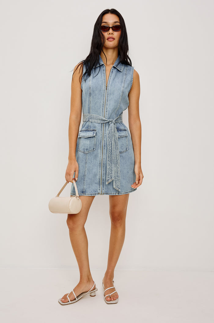 Aurora Sleeveless Mini Dress in TENCEL™Denim With Collar Front Exposed Zipper Adjustable Belted Ties Side Flap Pockets in Faded Indigo Colorway - Full Body Front View Featured on Model