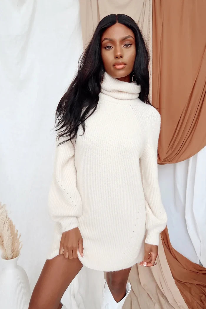 Model in the Beau ivory knit sweater dress with roll neck and slouchy sleeves.