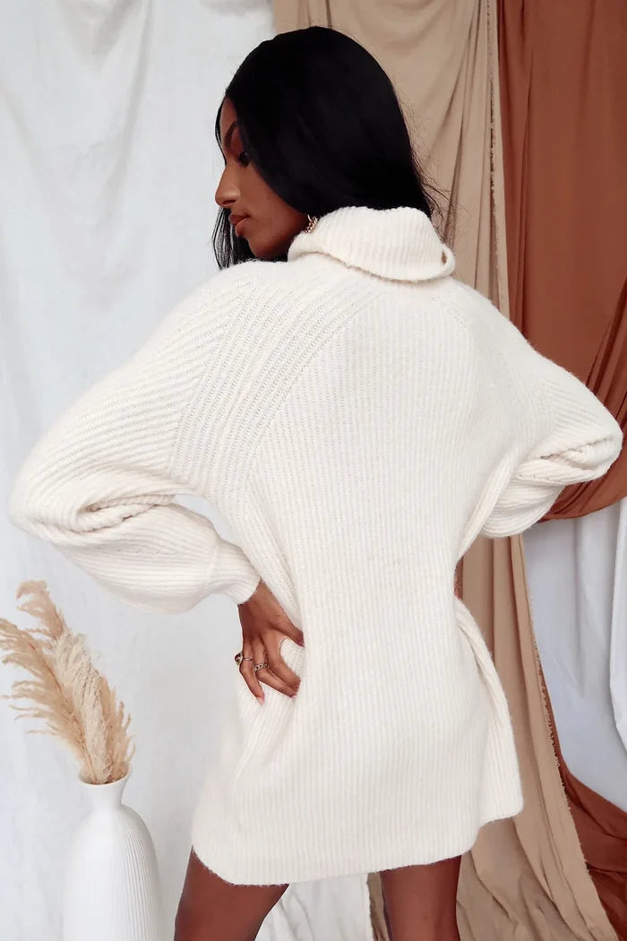 Back view of the Beau ivory ribbed knit sweater dress with roll neck and slouchy sleeves.