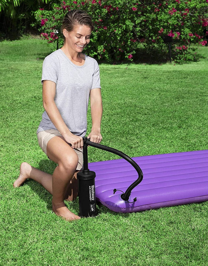 Black Bestway Air Hammer inflation pump with hose inflating purple mattress