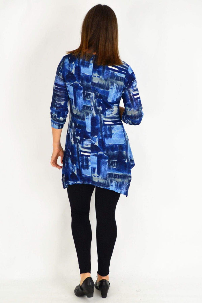 Blue Stylius Nova Tunic Top with relaxed fit and long sleeves, displayed on a hanger against a neutral background.