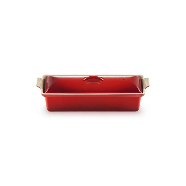 Red rectangular terrine mold with beige handles on a white background