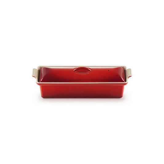 Red rectangular terrine mold with beige handles on a white background