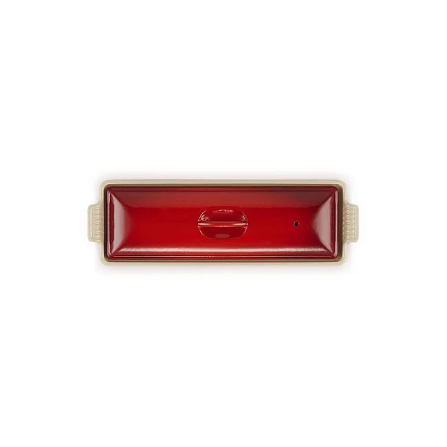 A rectangular red ceramic baking dish with a glossy finish, a small embossed logo in the center, and light beige handles on the sides, shown against a plain white background.
