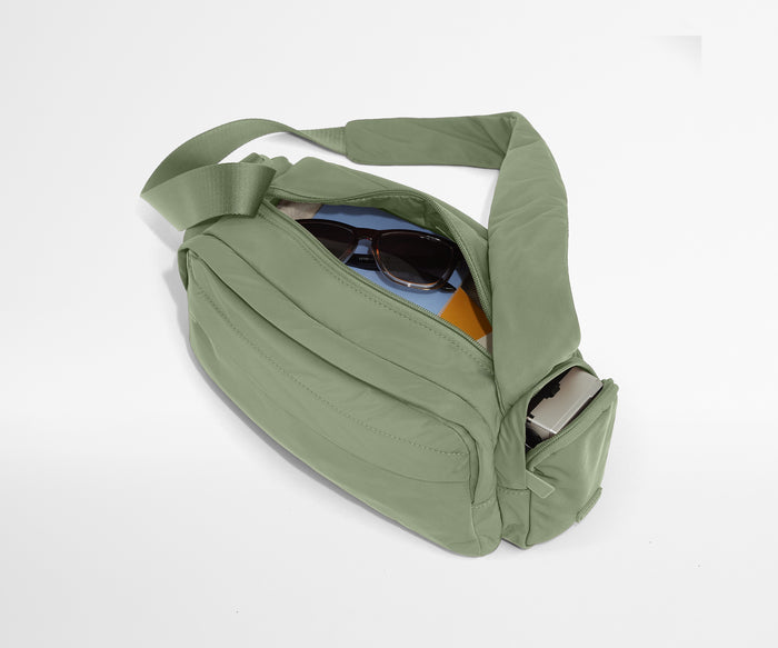 Featherlight Cargo Pack packed with notebooks, sunglasses, and a camera