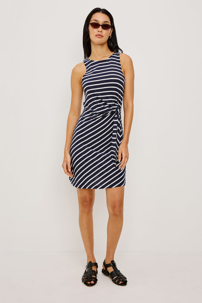 Harriet Mini Dress in Cotton With HIgh Neckline Waist Wrap Ties and A-Line SKirt in Navy Ivory Stripe Colorway - Full Body Front View Featured on Model