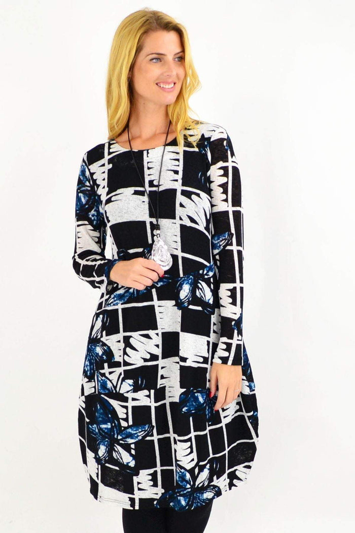 Vuios Heidi floral cocoon tunic dress with vibrant floral patterns and relaxed fit, modeled on a woman standing outdoors.