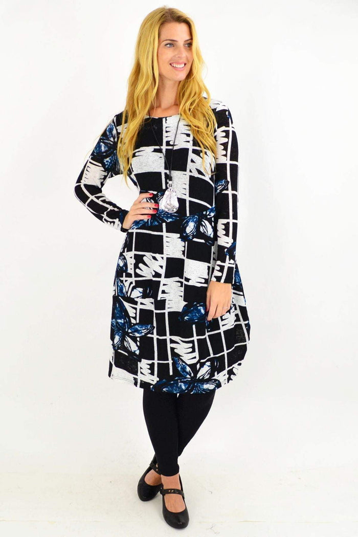 Vuios Heidi Floral Cocoon Tunic Dress displayed on a hanger with colorful floral patterns and flowing fabric.