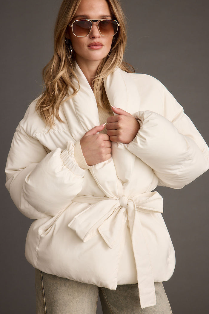 Full-length view of the white jacket showing the drape and movement.