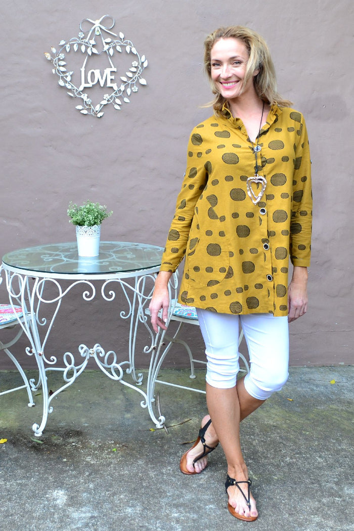 Mustard spot high collar tunic shirt by Ruby Rain, featuring a stylish collar and relaxed fit, shown on a hanger.