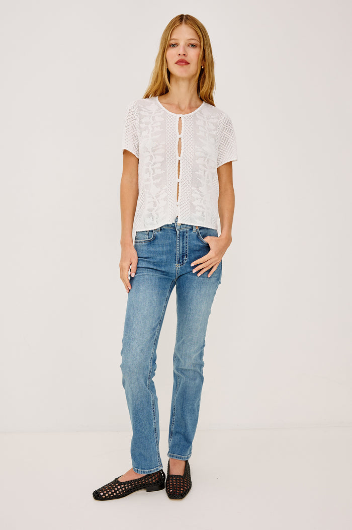 Nina Top in Sheer Netted Lace With Scoop Neckline, Front Cutouts With Self-Covered Buttons, Short Sleeves, and a Boxy, Cropped Silhouette in Ivory Colorway - Full Body Front View Featured on Model
