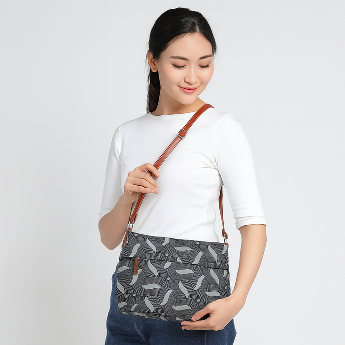 Olive green printed canvas shoulder‑sling bag with soft relaxed silhouette for travel and everyday use-model image