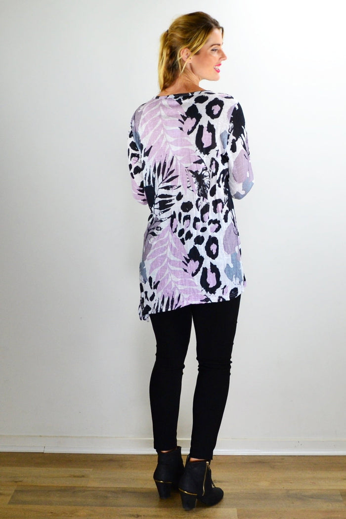 Pink jungle print crinkle tunic top by Cafe Latte with a relaxed fit and vibrant tropical pattern, shown on a hanger.