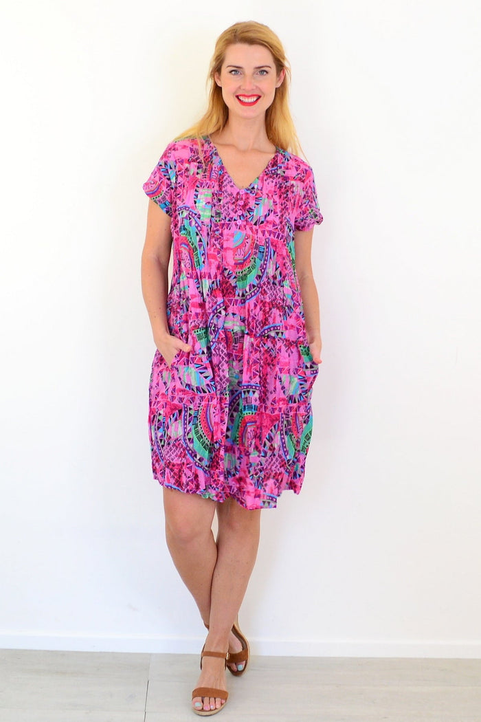 Pink tropical Nicola tunic dress with cap sleeves from One Summer, featuring vibrant floral pattern and lightweight fabric.