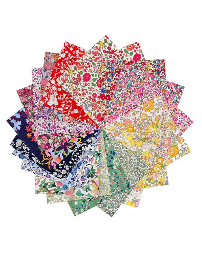 Stack of colorful floral fabric swatches on a white background