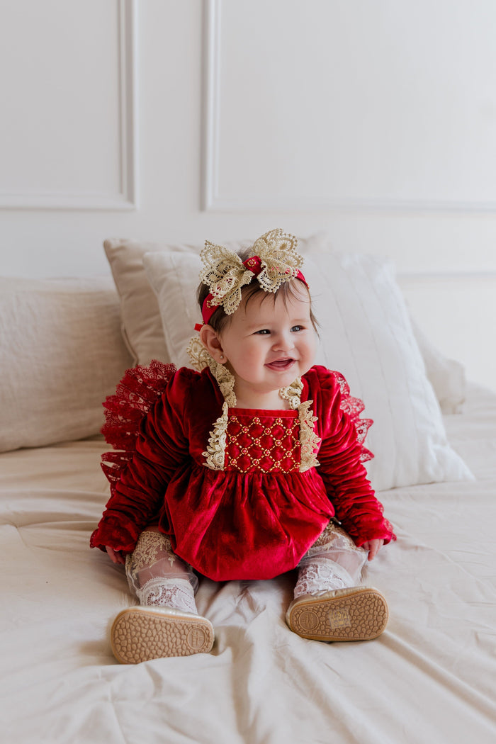 Victoria red velvet hair sash styled on a baby, showcasing the lace bow detail and rich velvet texture